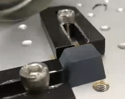 An animation of a laser marker etching away the word 'Thru' on a painted keycap.